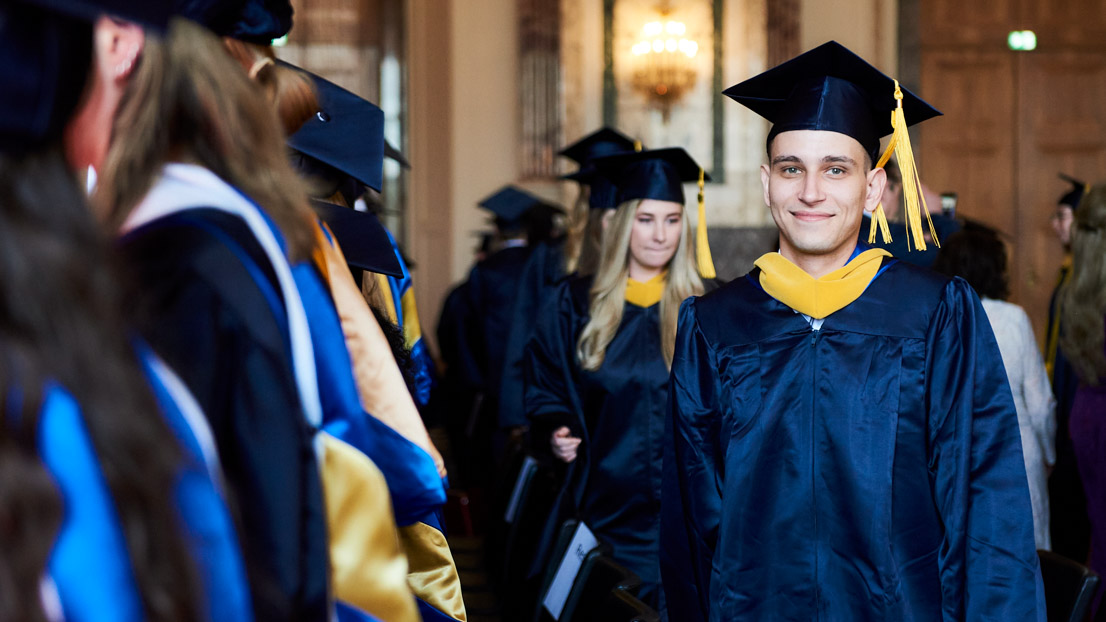 a smiling student in the crowd at Webster University in Vienna commencement 2022
