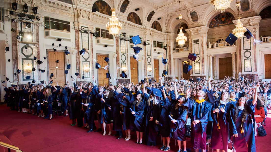 celebrating by throwing caps in the air, Webster University in Vienna commencement 2022